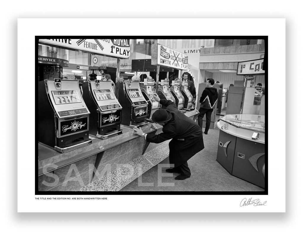 an exclusive black and white photograph of a high roller on a fruit machine by british photojournalist arthur steel