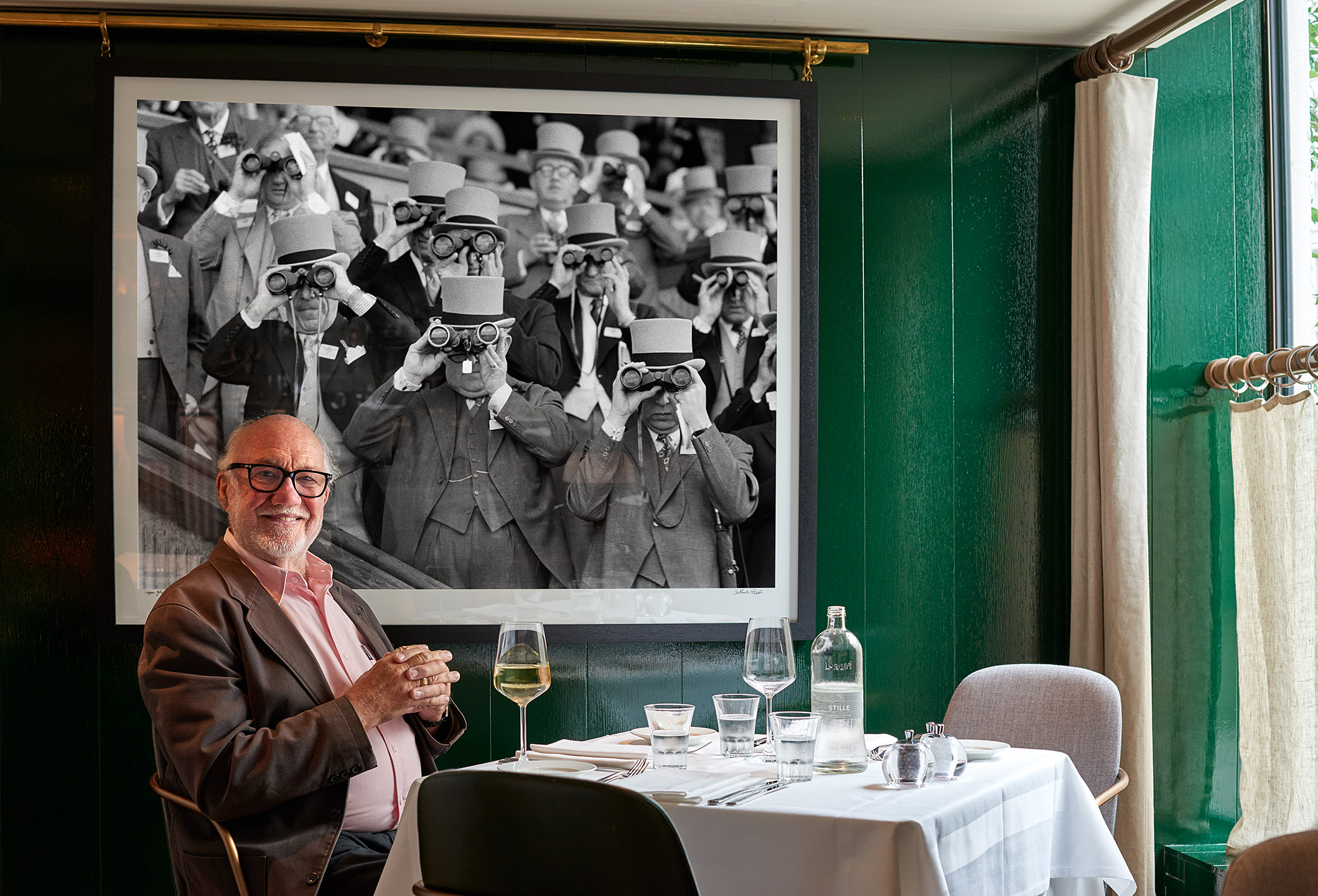 arthur steel sitting beneath his photograph of upeer glasses at the hari hotel in mayfair london